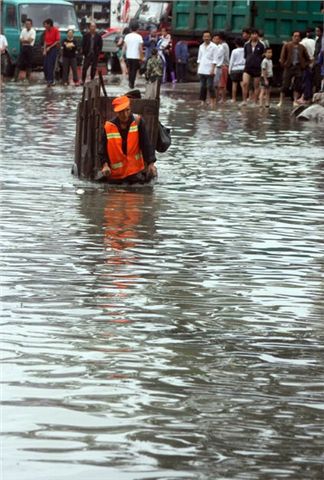 清洁工洪水中不忘捡垃圾 手臂带孝令人感动